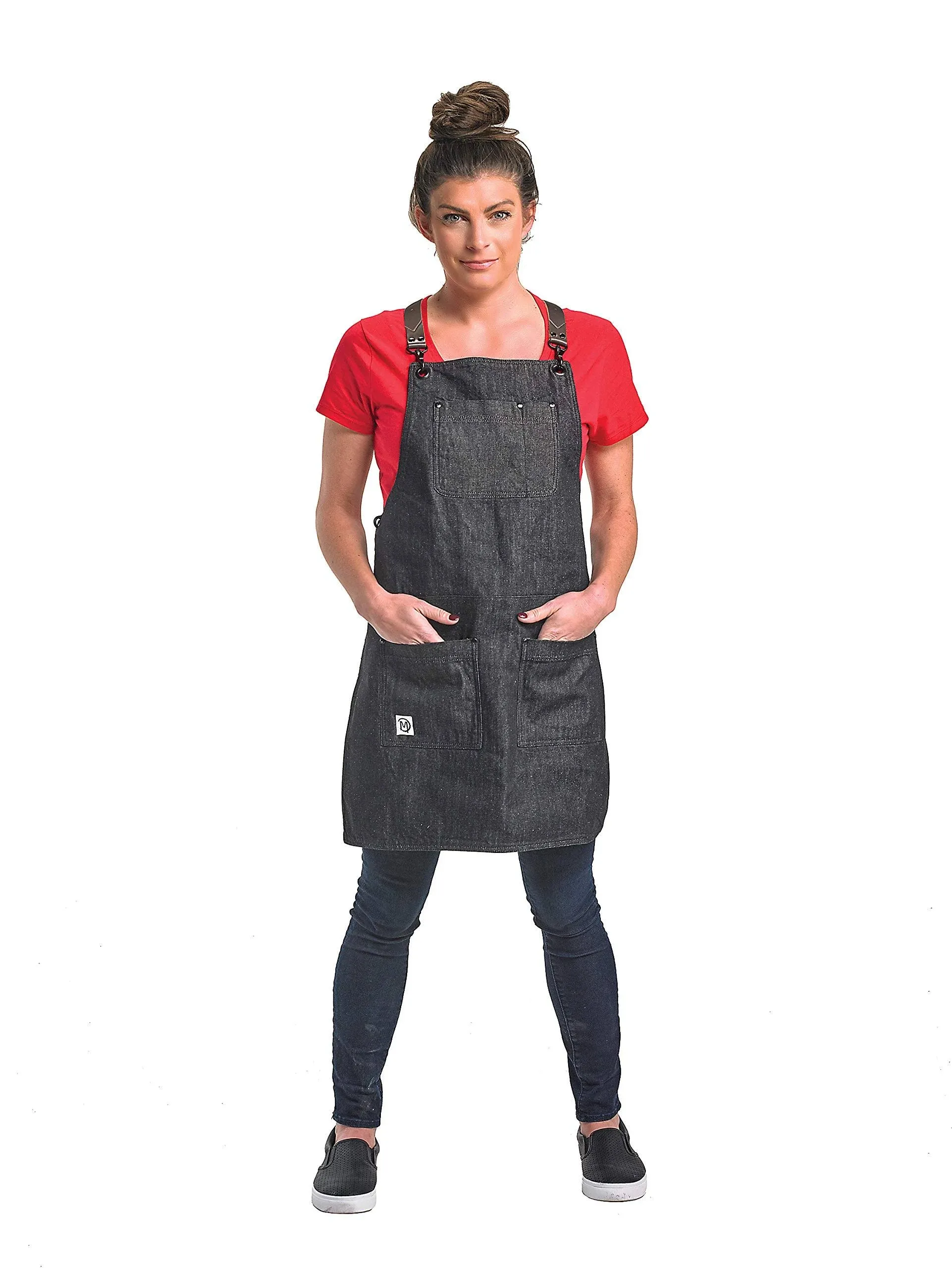 Renegade Bib Apron, 25in. x 30-1/2in., l leather cross-back straps and powder coated metal closures, (3) exterior pockets and (2) interior pockets, adjustable straps easily removed, black rivet accents at pocket corners, 100prcnt. cotton denim, black with brown leather straps